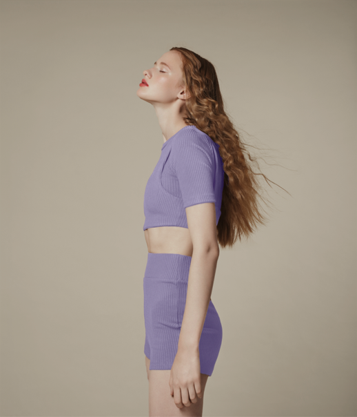 Profile image of a women standing up with her eyes closed and head tilted upwards.