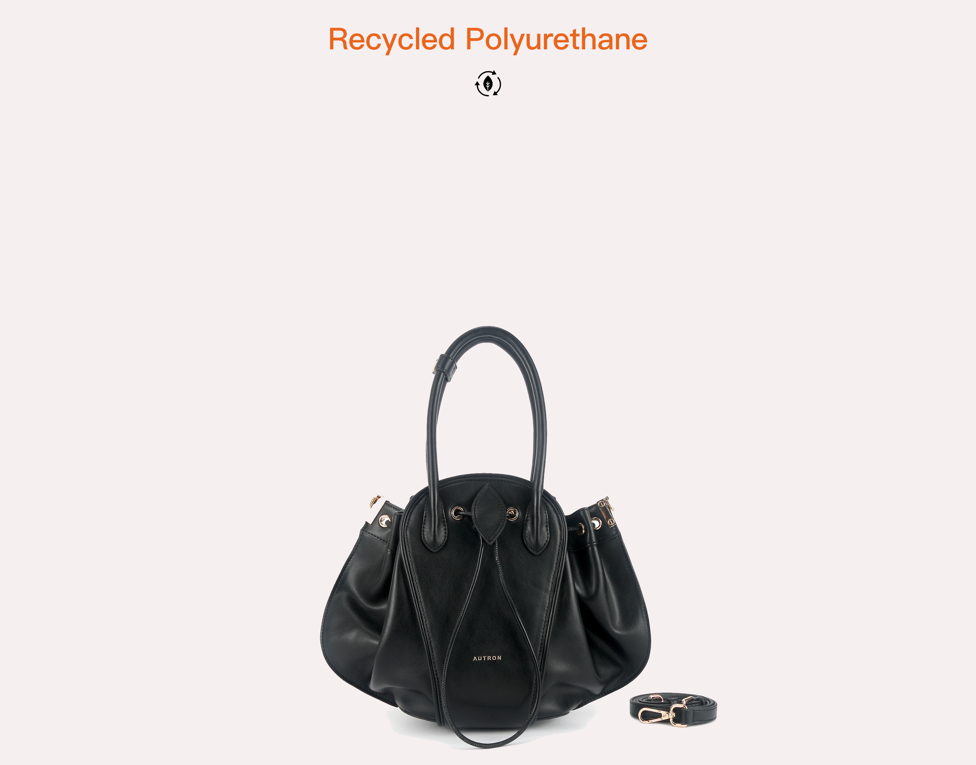 Black sculptural tote bag with rounded side panels, drawstring detail, padded handles, and gold-tone hardware.
