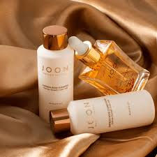 Joon hair products displayed on golden fabric at Hello Beautiful Salon Houston