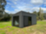 Exterior view of a tiny home showcasing monument Colorbond tin & flashing and energy-efficient double glazed windows