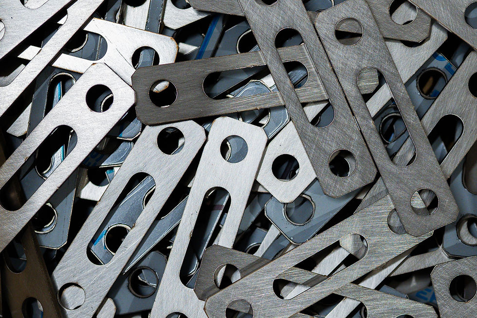 A pile of metal brackets laser cut and machined at MW Campbells.