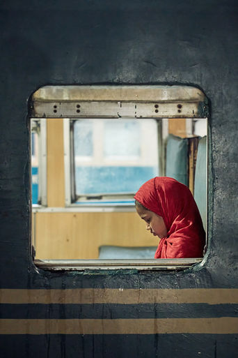A young girl reads inside a train at Dhaka station, Bangladesh.