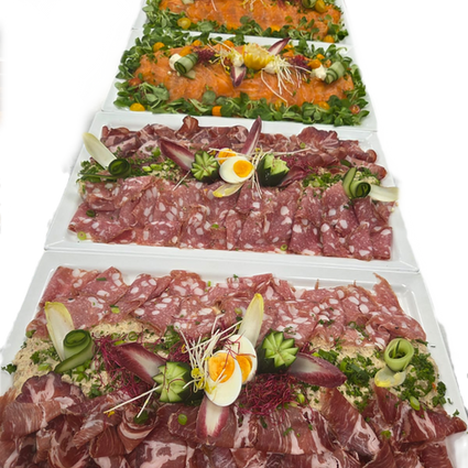 Luxe buffet met schalen koude vleeswaren, vis en ei.