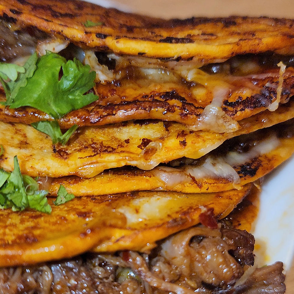Close-up view of a golden, crispy quesabirria taco filled with shredded beef and melted cheese