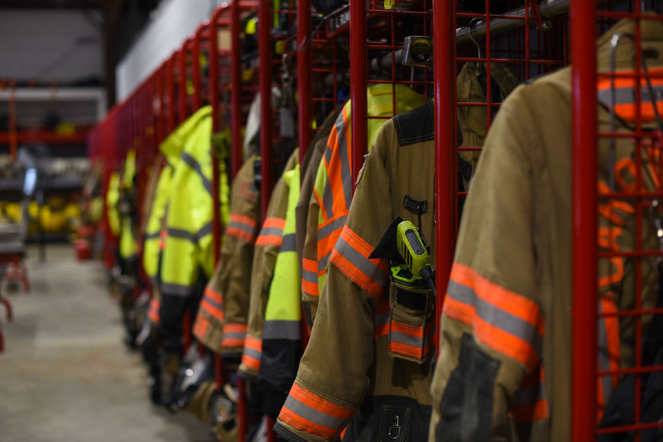 Firefighters' turnout gear hanging neatly in station