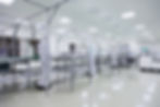 Workers in cleanroom suits assembling products on a cleanroom floor