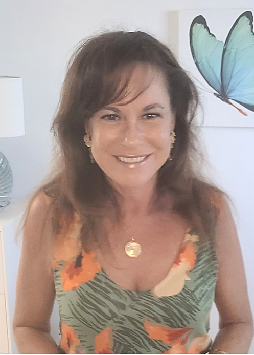Michele Harris in orange and green dress in her office