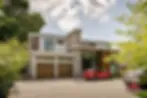 Modern house with double garage and two cars in driveway