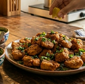 Crispy golden Amritsari Fish Fry served on a plate with green chutney and onion rings