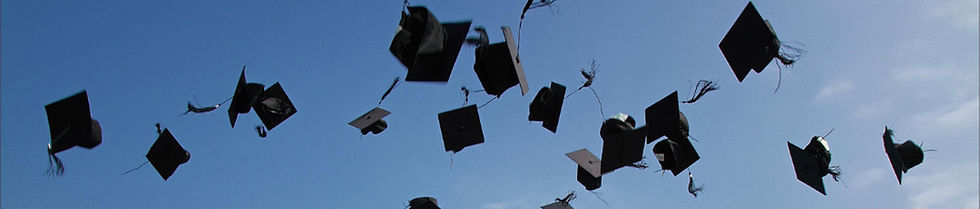 Graduation caps tossed in blue sky