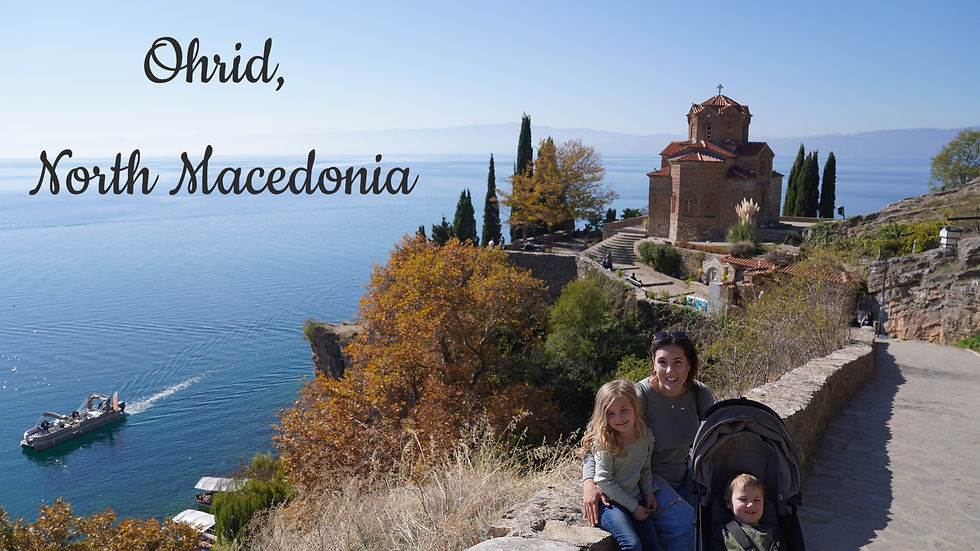 Smiling family by a stroller on a sunny path, with a historic church, trees, and a boat on Lake Ohrid. Text: Ohrid, North Macedonia.