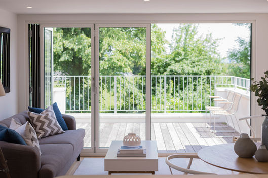 Living room space with glass doors and roof terrace (apartment C)
