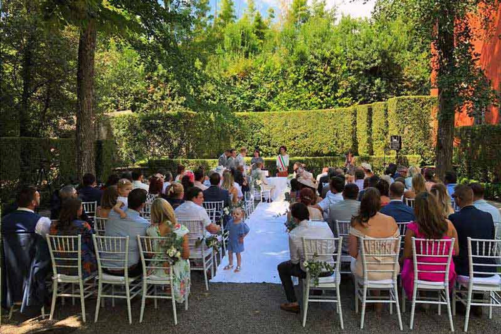 The ceremony area was surrounded by tall trees, providing some relief from the heat.