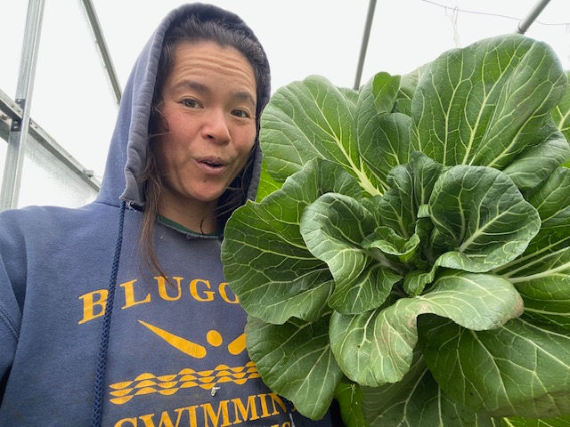 Sarah happily holding up large head of cabbage