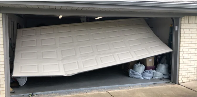 White sectional garage door tilted severely across the opening