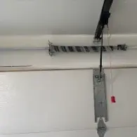 Owner of Trinitron Garage Doors installing a new garage door opener motor during a residential garage door repair service.