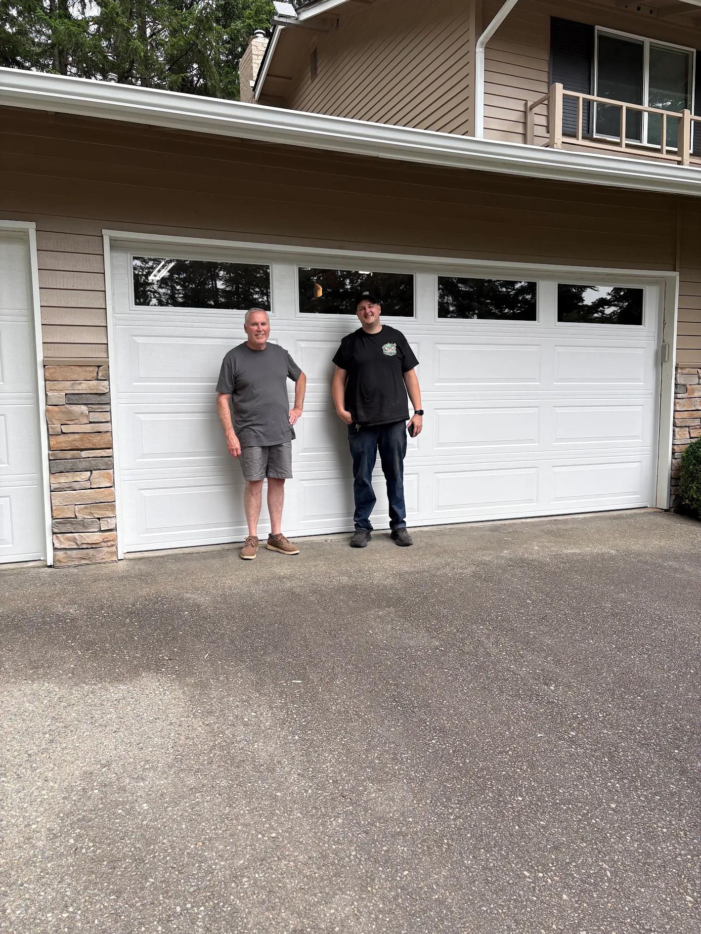 Wesley and the homeowner beside a finished white garage door with windows in Gig Harbor