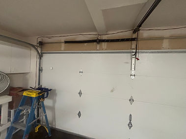 Owner of Trinitron Garage Doors installing a new garage door opener motor during a residential garage door repair service.