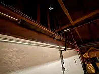 Owner of Trinitron Garage Doors installing a new garage door opener motor during a residential garage door repair service.