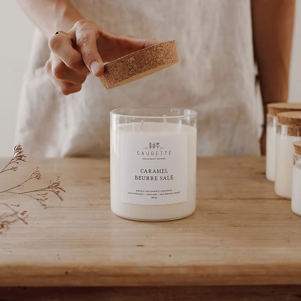 Main ouvrant le couvercle en liège d'une bougie Saugette parfum caramel beurre salé, sur table en bois – idée cadeau fête des mères Les Jolies Emplettes