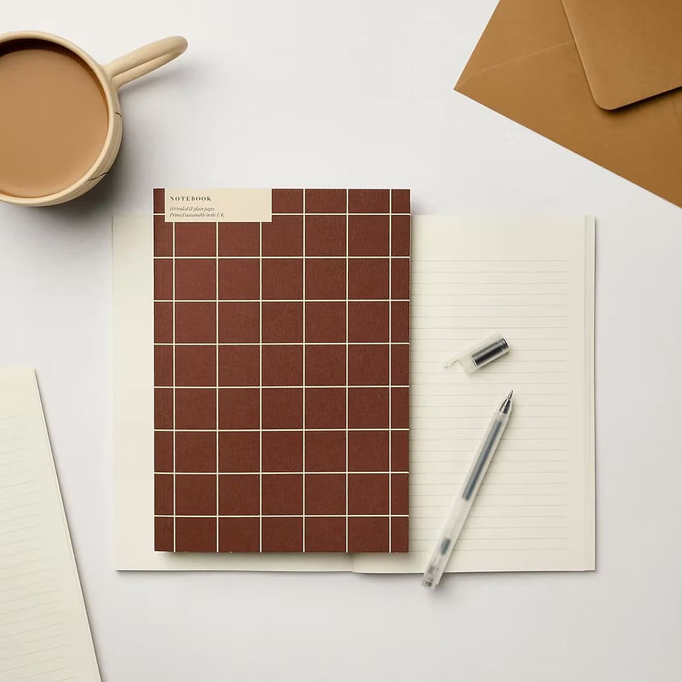 Carnet à couverture carreaux brun et crème ouvert sur un bureau avec tasse de café et enveloppe kraft – papeterie slow living Kinshipped Les Jolies Emplettes