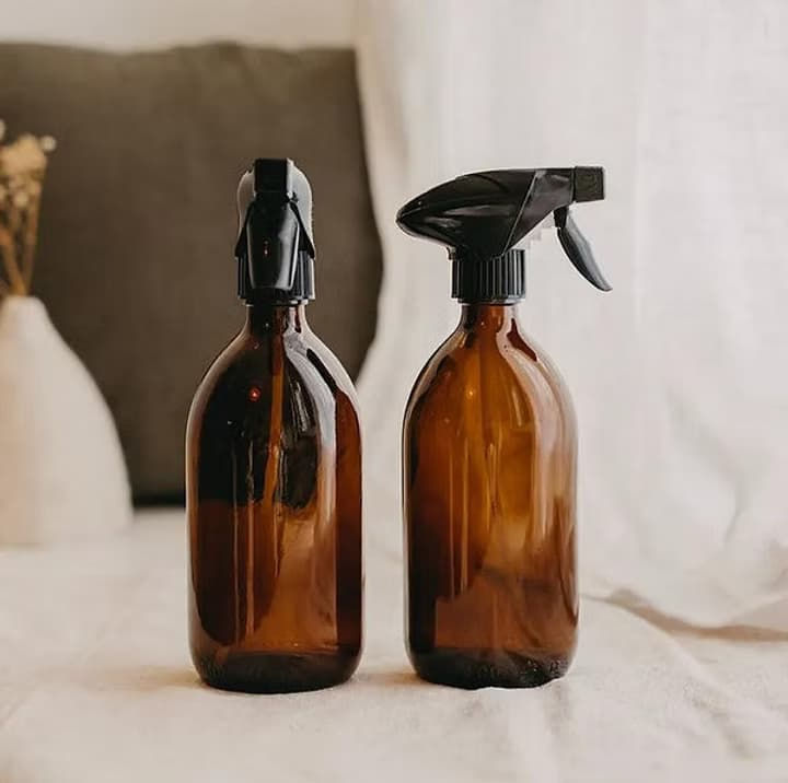 Deux flacons spray en verre ambré réutilisables posés côte à côte sur un lit en lin – ménage naturel zéro déchet Little Pots Les Jolies Emplettes