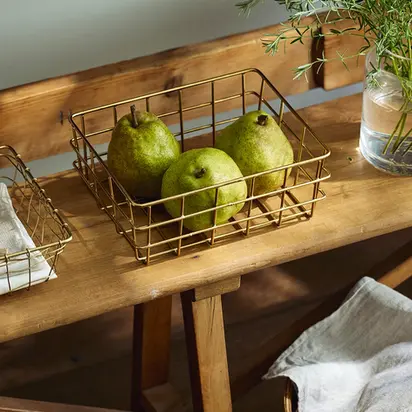 Panier doré rempli de poires, posé sur un banc en bois – Collection Automne Les Jolies Emplettes