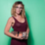 Professional headshot of woman with glasses holding book