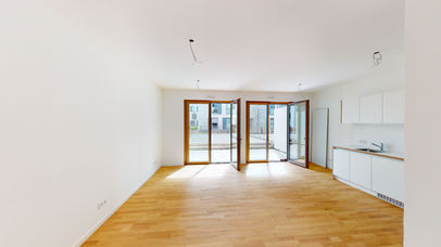CURVE Wiesbaden - heller Wohnraum mit Fensterfront und angrenzender Küche