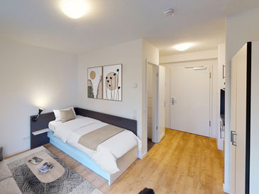 Focus Homes Leipzig - möbliertes Apartment mit Bett und Sitzecke