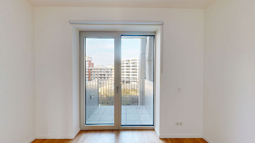 John Jahr Haus Berlin - Zimmer mit bodentiefer Balkontür und Blick auf die Nachbarbebauung
