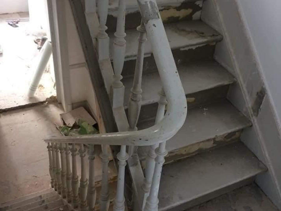 Avant : escalier vétuste, peinture écaillée sur les marches et la rampe