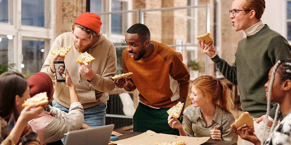 Group of co-workers enjoying pizza during lunch break due to catering.
