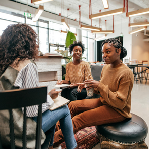 Diverse group of professionals having a team discussion in a modern office, practicing emotional resilience and authentic leadership in the workplace.