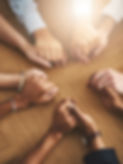 People holding hands at a group therapy session.
