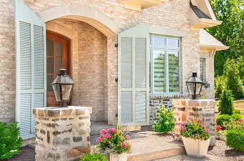 Elegant custom home entryway in Lebanon, Ohio built by Frazier Homes, featuring hand-crafted stonework, custom shutters, and refined architectural details that showcase exceptional craftsmanship.