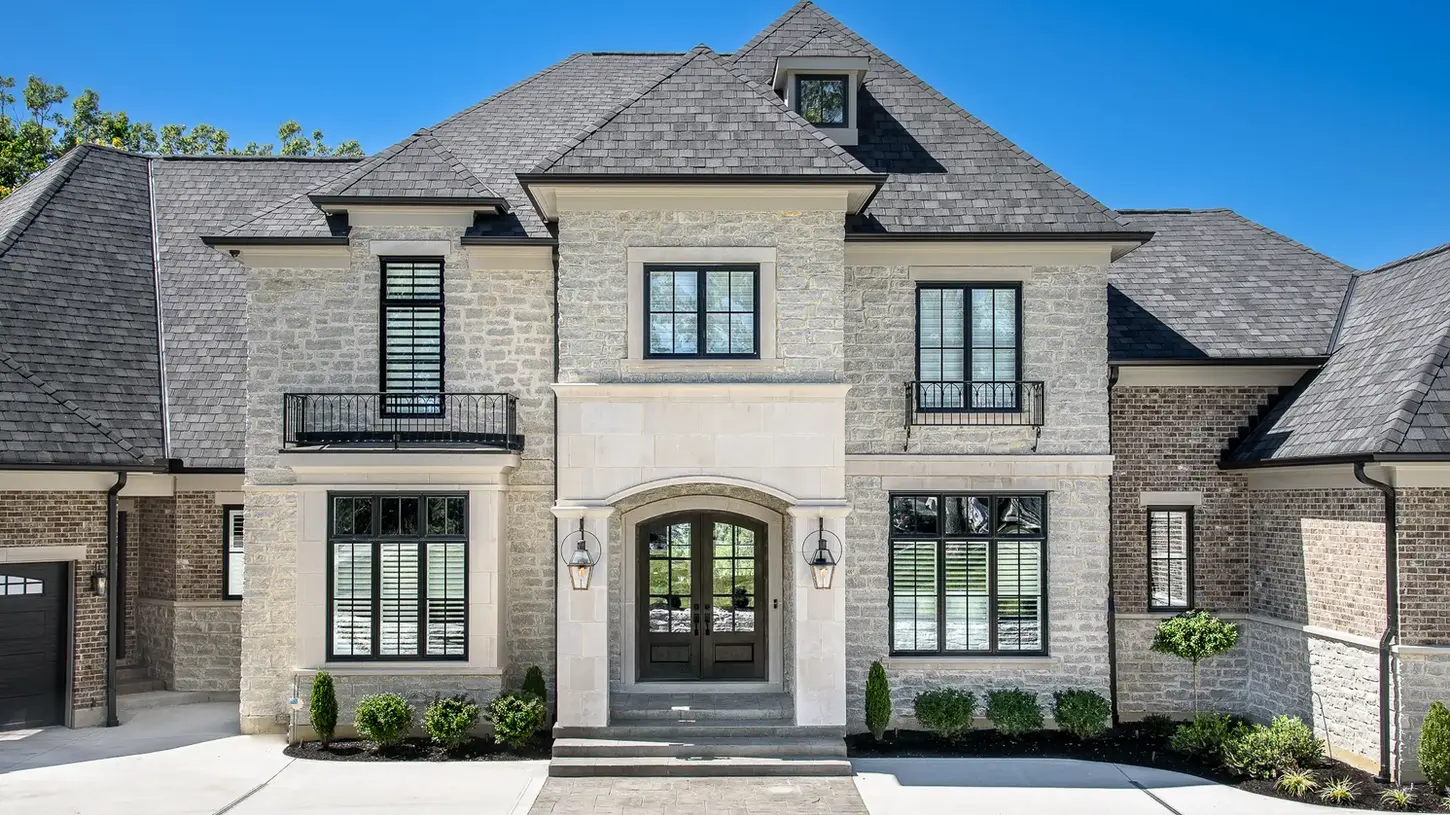 Luxury custom home in Hyde Park by Frazier Homes featuring a stone and brick exterior, symmetrical architecture, refined detailing, and timeless design rooted in proportion, craftsmanship, and long-term livability.