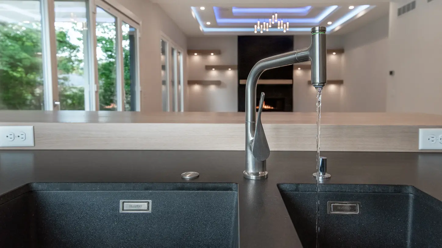 Luxury kitchen faucet with running water over dual Blanco sinks in the Montgomery custom home by Frazier Homes.