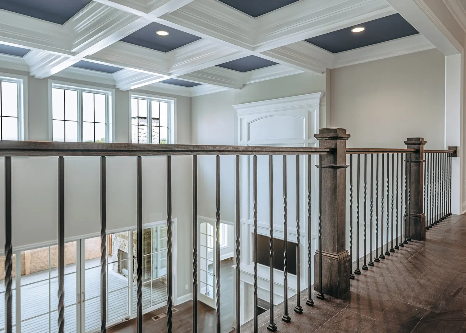 Hyde Park luxury home overlooking two-story living room with custom wood railing, twisted iron balusters, and detailed coffered ceiling by Frazier Homes.