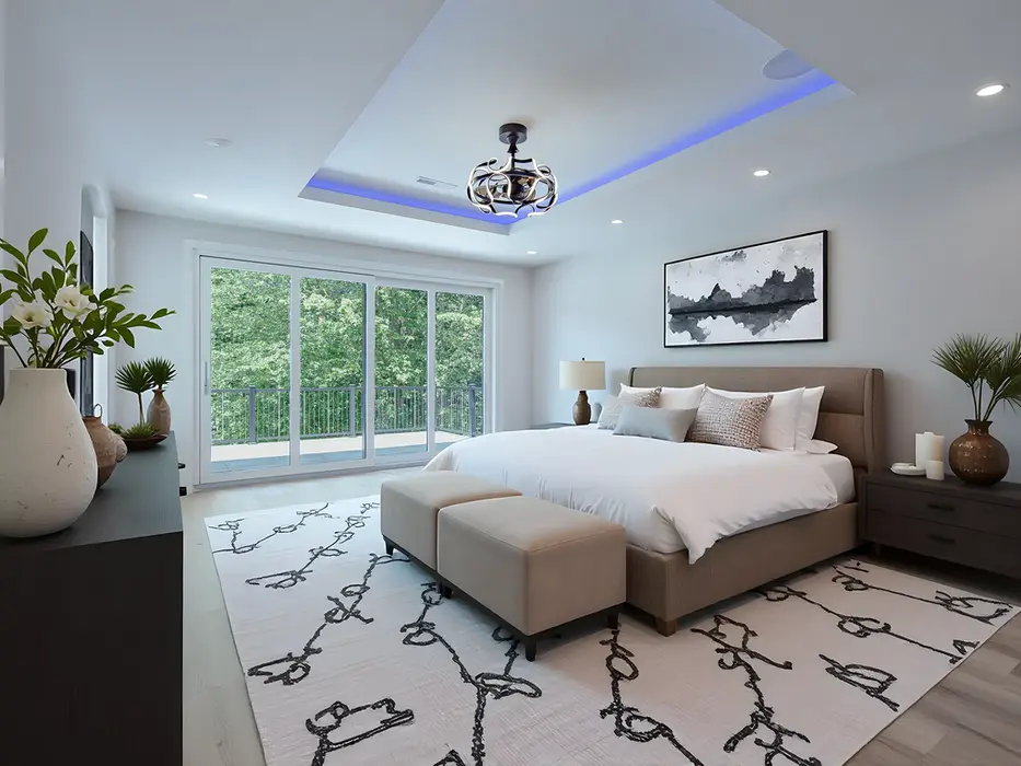 Luxury master suite in Montgomery, Ohio custom home featuring tray ceiling with LED lighting, sliding glass doors to private balcony, neutral décor, and modern furnishings by Frazier Homes.