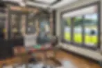 Luxury home office at Frazier Homes’ Homearama award-winning build featuring custom black built-in cabinetry, modern lighting, large picture window, and premium wood flooring.