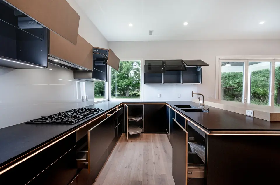 Modern custom kitchen in Montgomery, Ohio featuring matte black cabinetry, integrated lighting, open shelving, and precision storage solutions by Frazier Homes.
