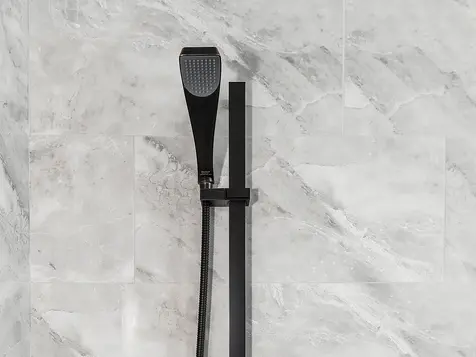 Luxury Liberty Township bathroom shower with gray marble tile and modern matte-black Delta fixtures by Frazier Homes.