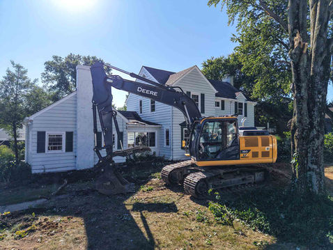 Excavator beginning the tear-down phase of a residential home, illustrating Frazier Homes’ approach to demolition as the first step in a thoughtful rebuild process.
