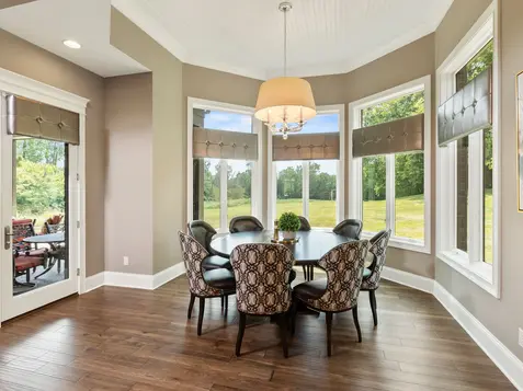 Light-filled custom dining room with large windows, round dining table, and refined finishes in a luxury Frazier Homes custom home in Lebanon, Ohio
