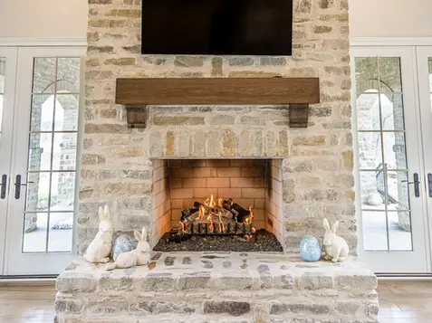 Full-height stone fireplace with custom wood mantel and built-in firebox constructed by Frazier Homes in a Lebanon luxury living room