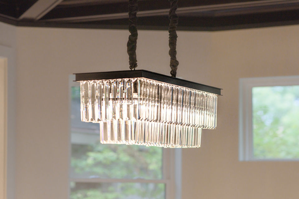 Crystal statement chandelier lighting in a Hyde Park Cincinnati dining room remodel with custom coffered ceiling by luxury builder Frazier Homes.