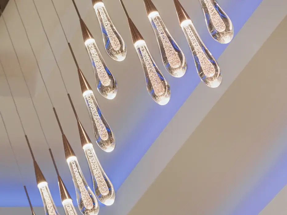 Modern teardrop glass pendant lighting fixture in Montgomery, Ohio custom home with cascading design and warm illumination by Frazier Homes.