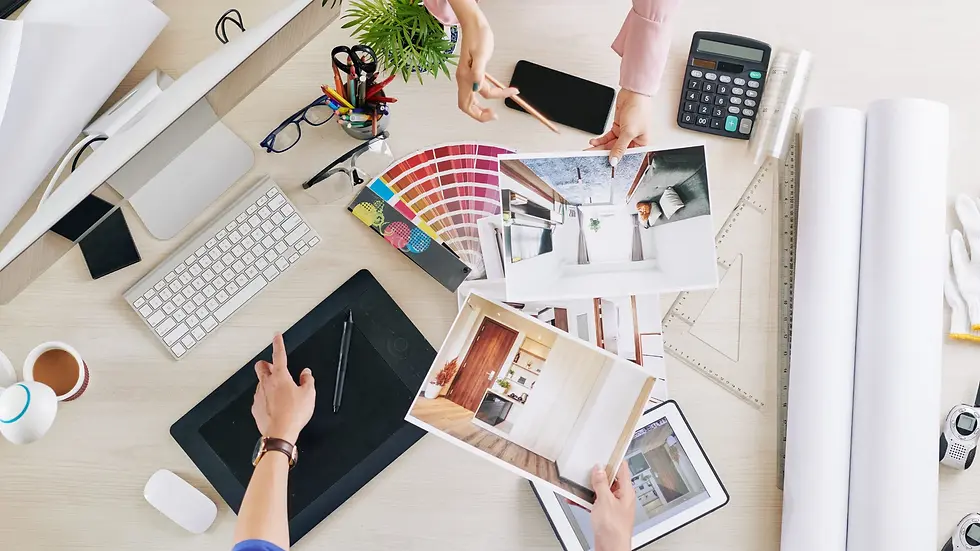 Overhead view of a custom home design planning workspace with finish samples, color swatches, interior photos, blueprints, and tools used during the home selections process.