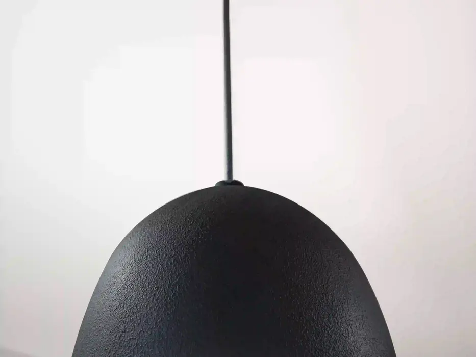 Modern matte black dome pendant light with warm metallic interior hanging above a luxury basement remodel kitchen designed by Frazier Homes in Cincinnati and Northern Kentucky.